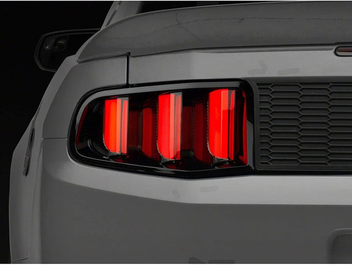 Raxiom 10-12 Ford Mustang Vector V2 LED Tail Lights - Gloss Black Housing (Clear Lens) - Bull Strap