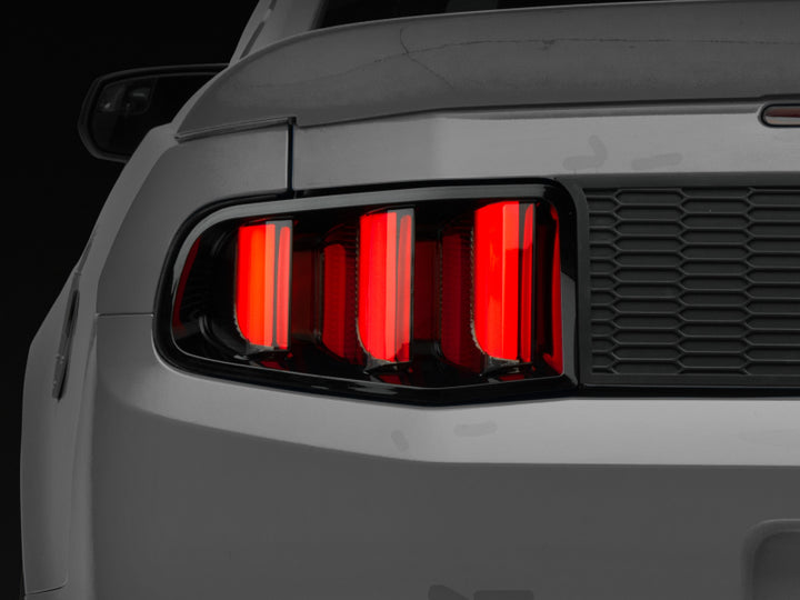 Raxiom 10-12 Ford Mustang Vector V2 LED Tail Lights - Gloss Black Housing (Clear Lens) - Bull Strap