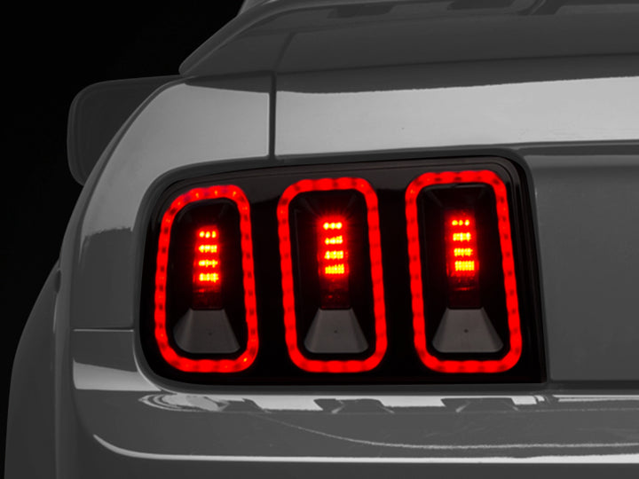 Raxiom 05-09 Ford Mustang Gen5 Tail Lights- Black Housing (Smoked Lens) - Bull Strap